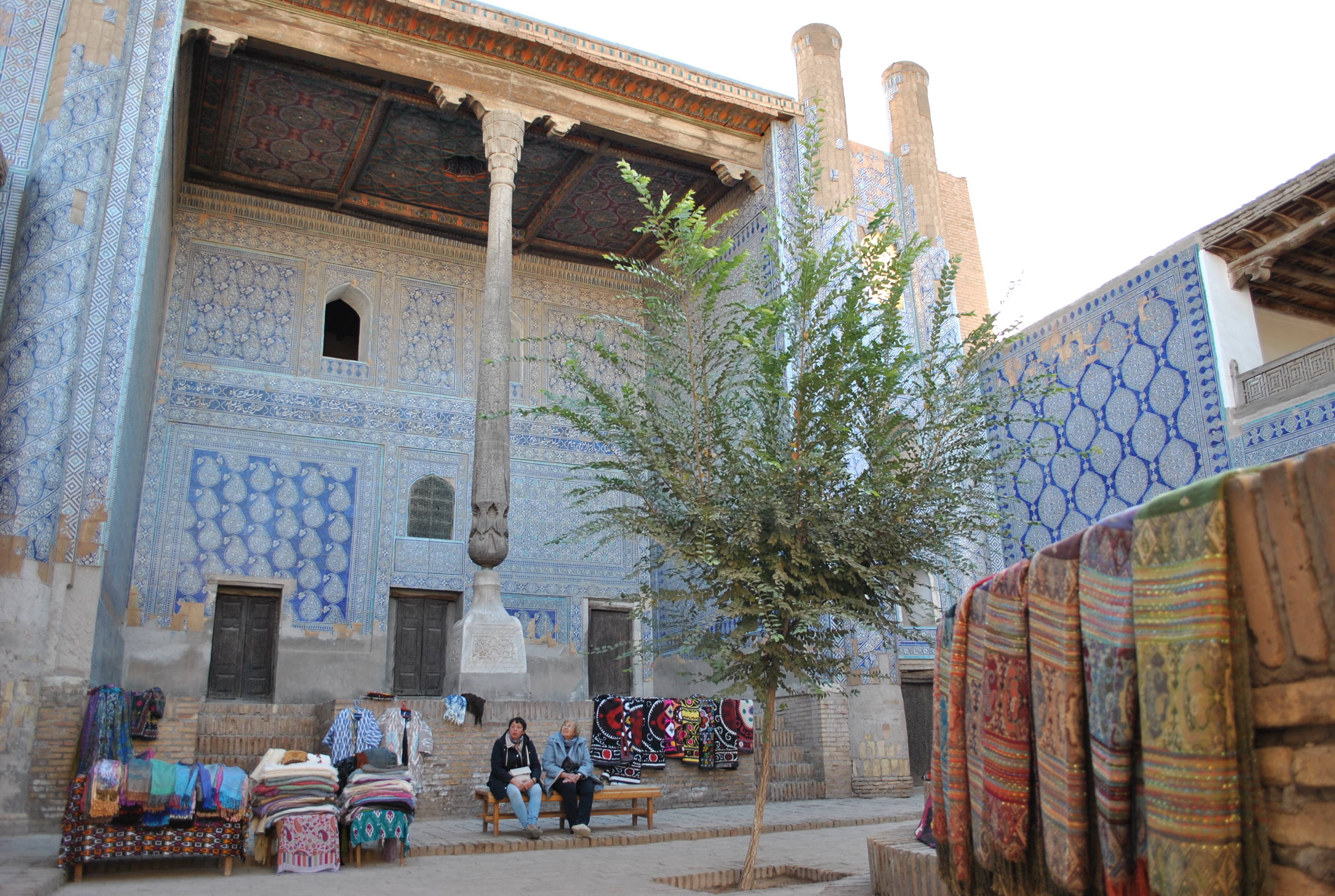 Visitors admiring Itchan Kala, the inner fortress of Khiva, full of craft vendors. 