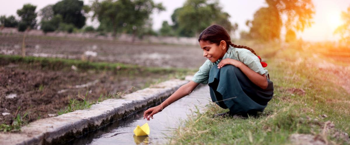 girl throwing a paper boat